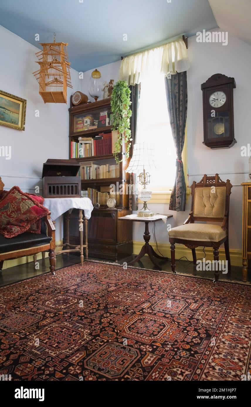 Sedia imbottita Eastlake e arredi antichi nella camera al piano superiore all'interno di una vecchia casa in stile cottage vittoriano del 1904. Foto Stock