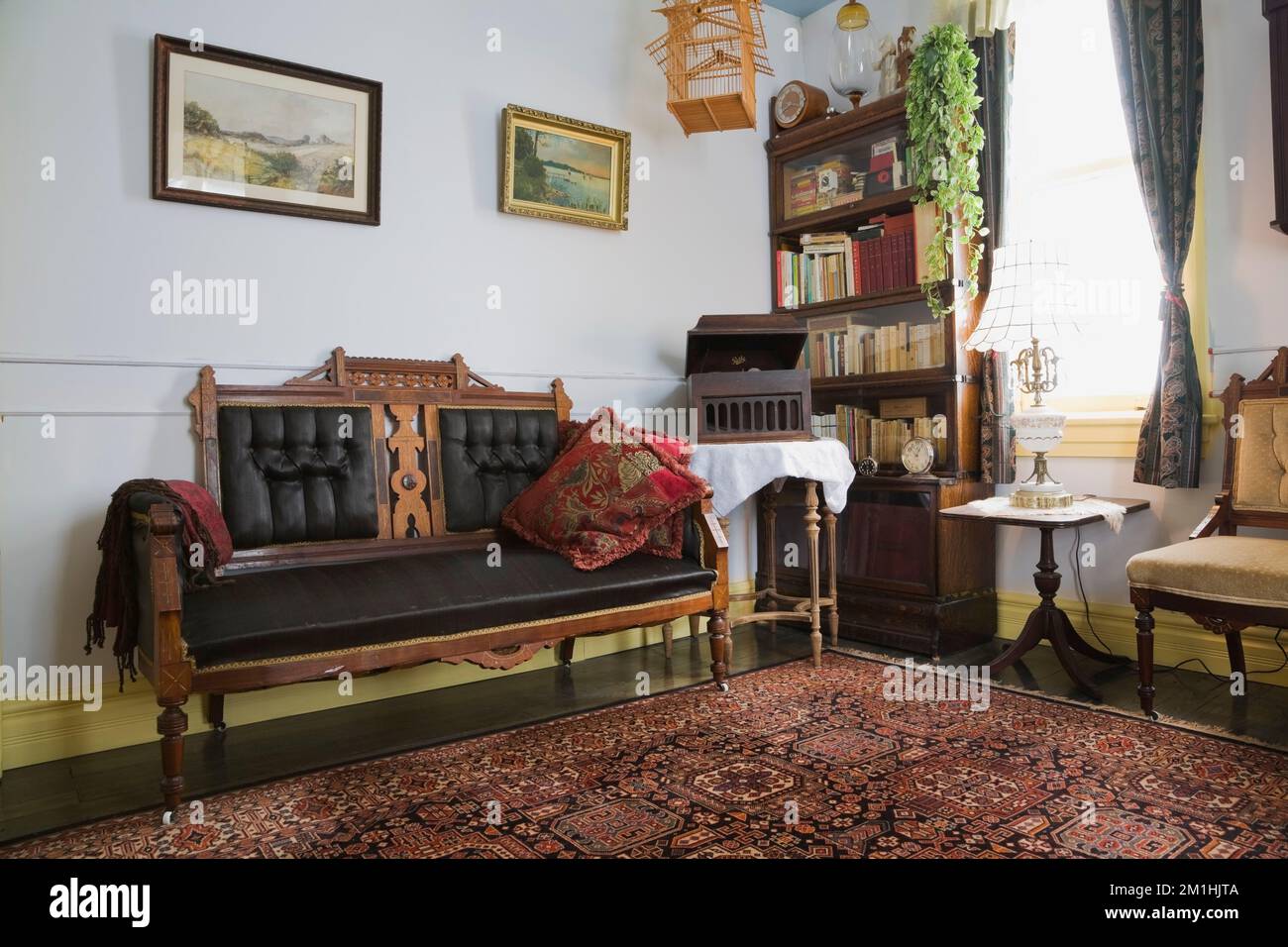 Divano Eastlake e sedia imbottita con mobili antichi nella camera al piano superiore all'interno di una vecchia casa in stile cottage vittoriano del 1904. Foto Stock