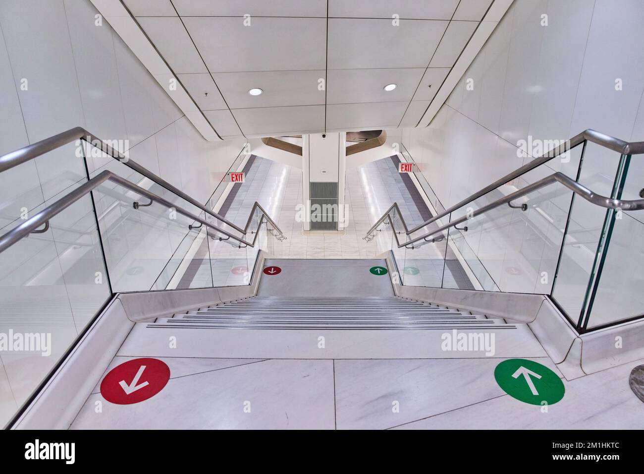 Le scale della metropolitana sono bianche e pulitissime e portano ai treni con una grafica a freccia rossa e verde Foto Stock