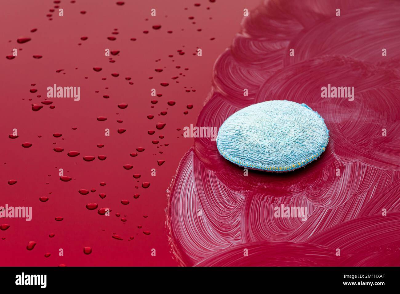 Auto cerante con gocce d'acqua, e cera sul cappuccio. Prima e dopo il confronto. Dettagli del veicolo, manutenzione automobilistica e concetto di assistenza. Foto Stock