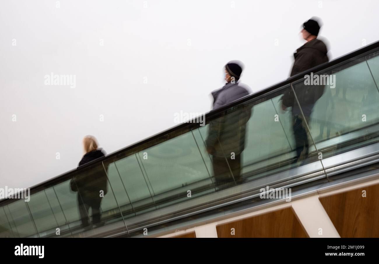 Persone che si precipitano nelle scale mobili. sfocatura del movimento. Persone in movimento nella scala mobile presso il centro commerciale. Messa a fuoco sfocata e selettiva Foto Stock