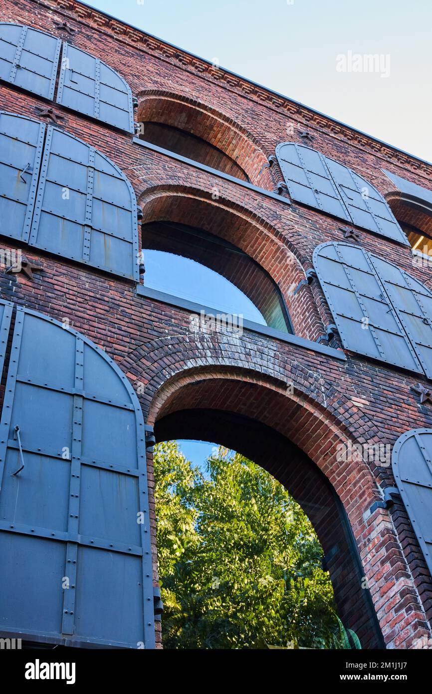 Edificio in mattoni con archi in legno e coperture in acciaio scuro Foto Stock