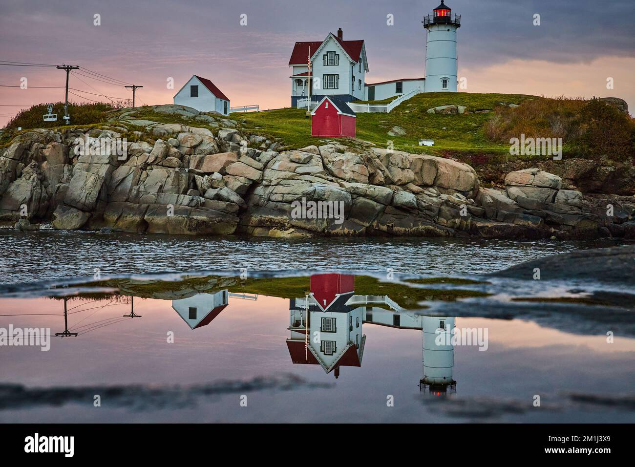 Il faro del Maine si riflette lontano dalla pozza con la luce del mattino Foto Stock