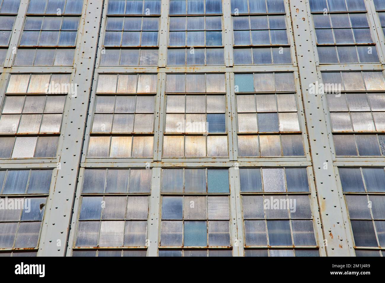 Parete infinita di piccole finestre industriali in diverse tonalità Foto Stock