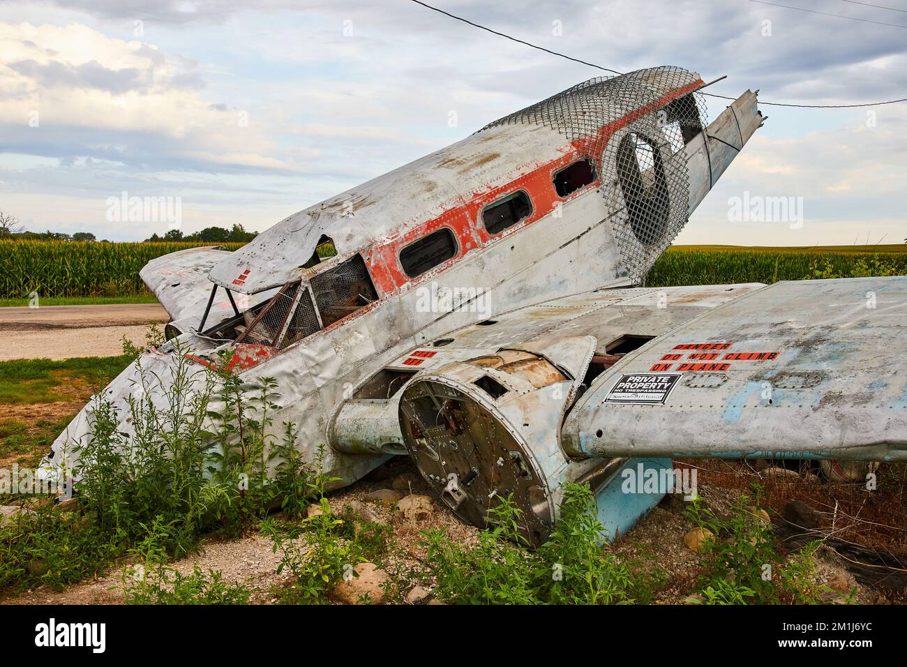 Vista laterale dell'aeroplano abbandonato distrutto che riposa sul campo Foto Stock