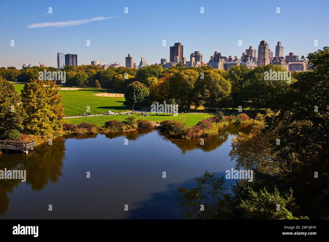 Stagno in Central Park con la città sullo sfondo New York City Foto Stock