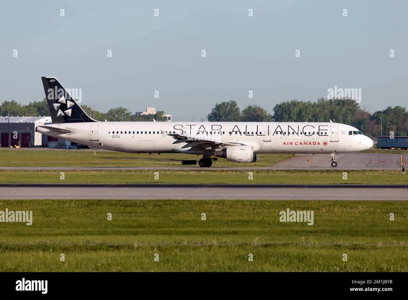 Un Air Canada Airbus 321 in Star Allianca livrea taxiing a Montreal Pierre Elliott Trudeau Int'l Airport.Star Alliance è la più grande alleanza mondiale di compagnie aeree. Fondato il 14 maggio 1997, il suo CEO è Jeffrey Goh e la sua sede centrale è situata a Francoforte sul meno, in Germania. Foto Stock