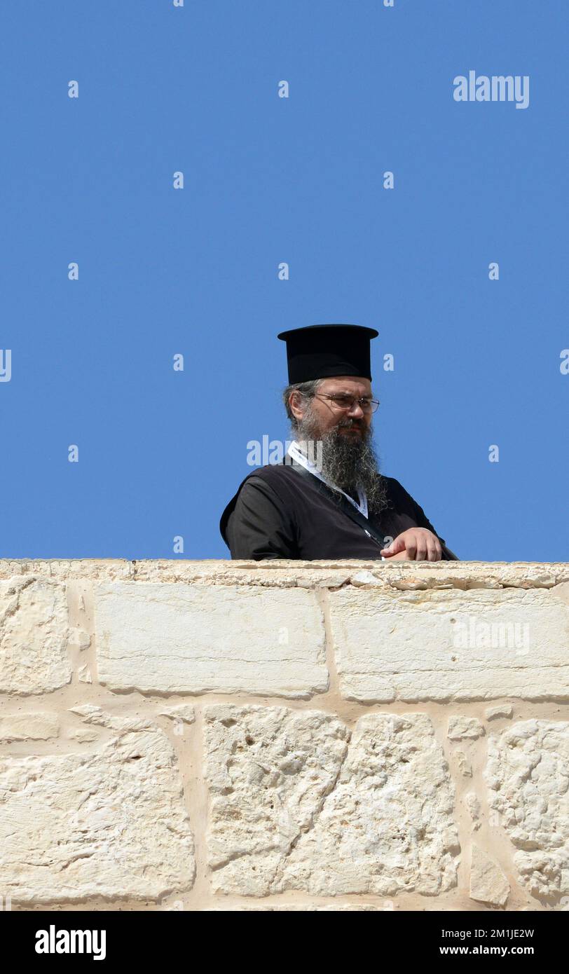 Sacerdoti greco-ortodossi in piedi nel cortile della Chiesa del Santo Sepolcro nel quartiere cristiano della città vecchia di Gerusalemme. Foto Stock