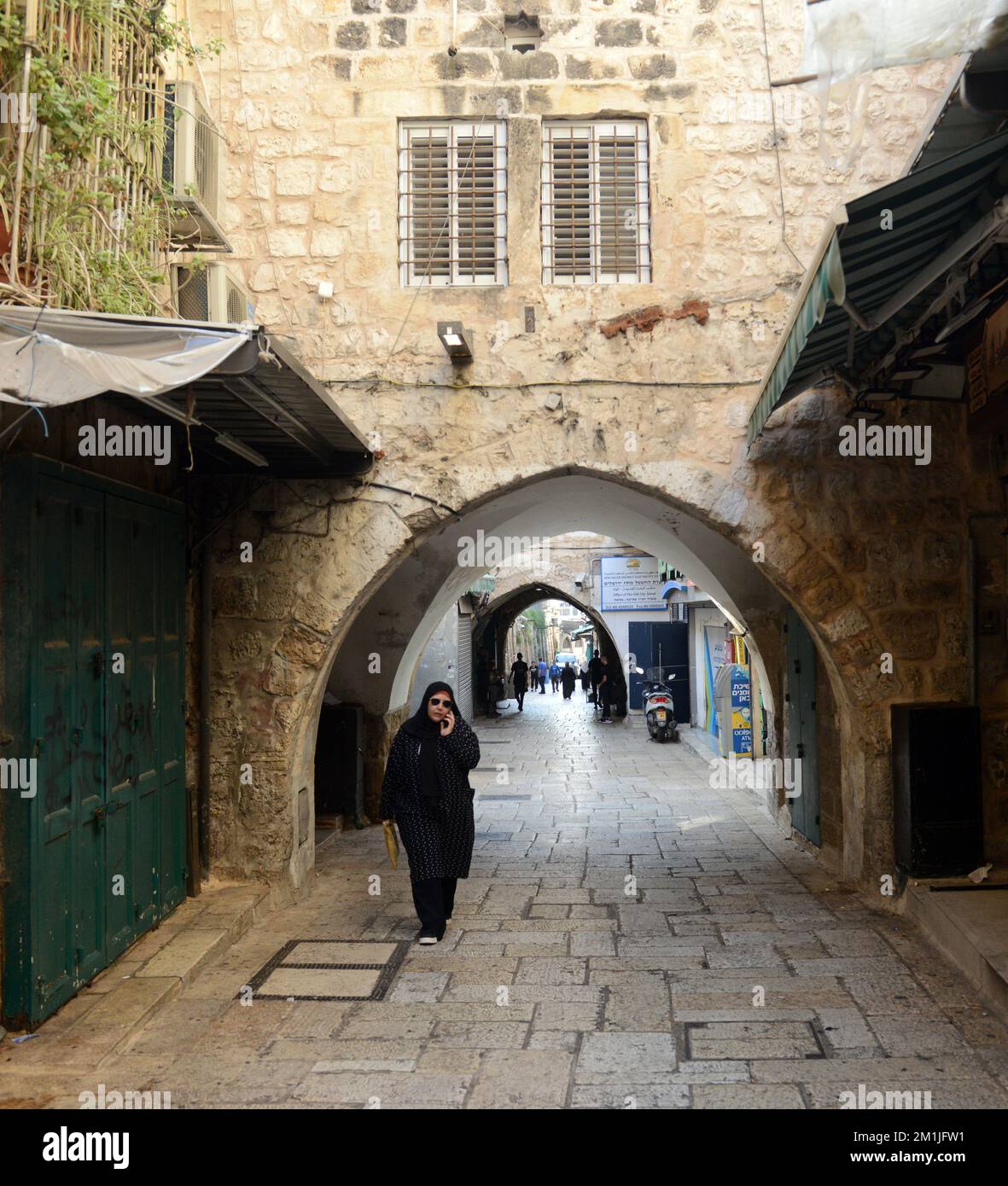 Una donna palestinese che cammina nel quartiere musulmano nella città vecchia di Gerusalemme. Foto Stock