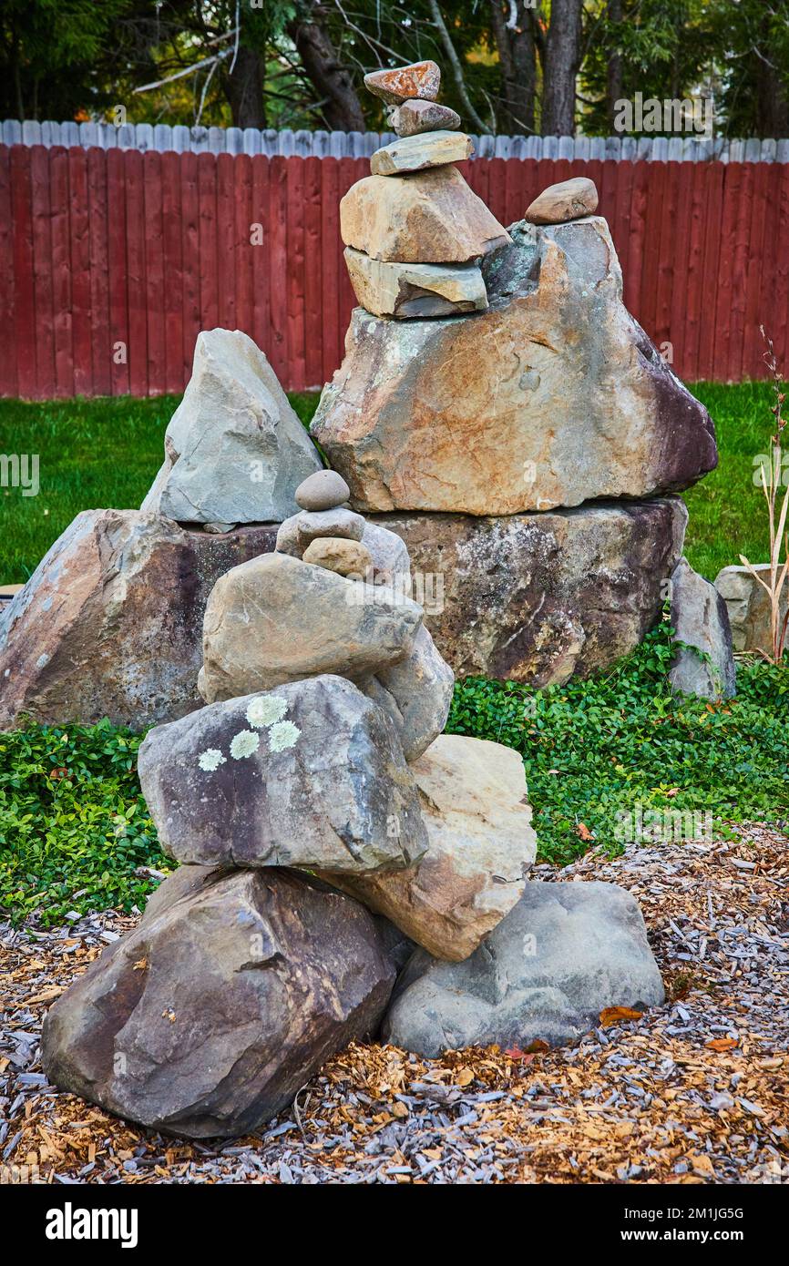Massi da cortile impilati uno sopra l'altro in stile Zen coirn con recinzione in legno Foto Stock