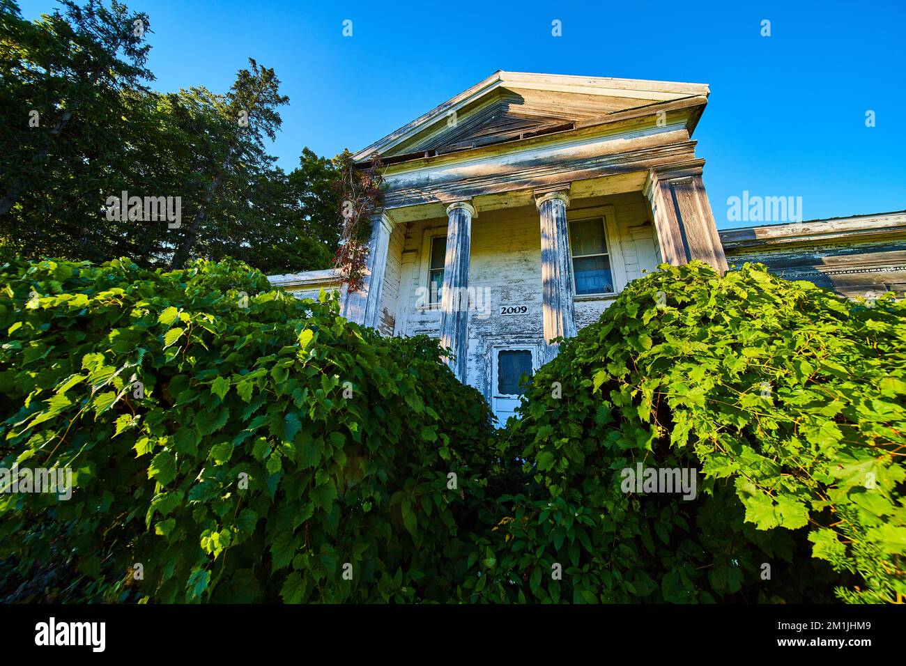 Residenza cittadina americana abbandonata in legno con grandi colonne bianche Foto Stock