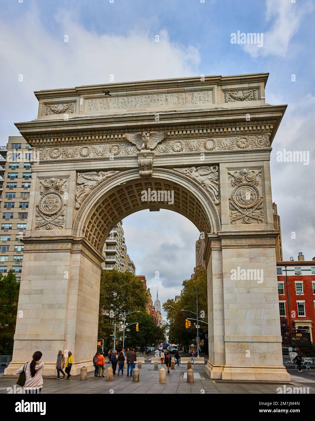 Vista panoramica di Washington Square Park enorme arco di pietra calcarea con pedoni Foto Stock