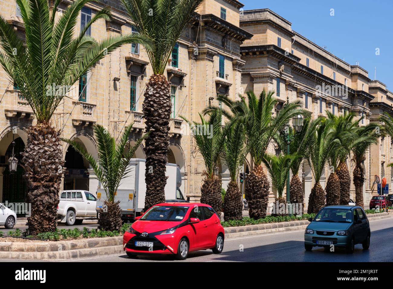 Lussureggianti palme verdi ed edifici panoramici in St Anne Street - Floriana, Malta Foto Stock