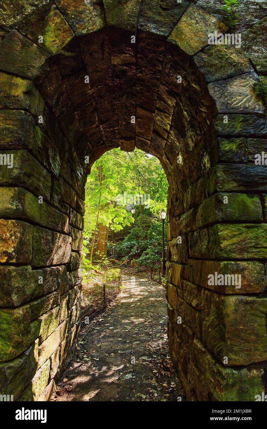 Tunnel ad arco in pietra nel dettaglio che va nei boschi sul sentiero a Central Park New York City Foto Stock