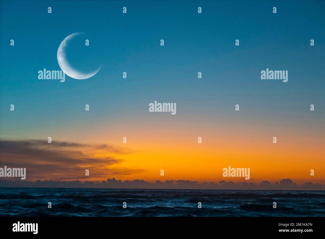 Luna nuova o Сrescent sopra l'oceano. Mezza Luna sul cielo luminoso della sera, spazio per il testo Foto Stock