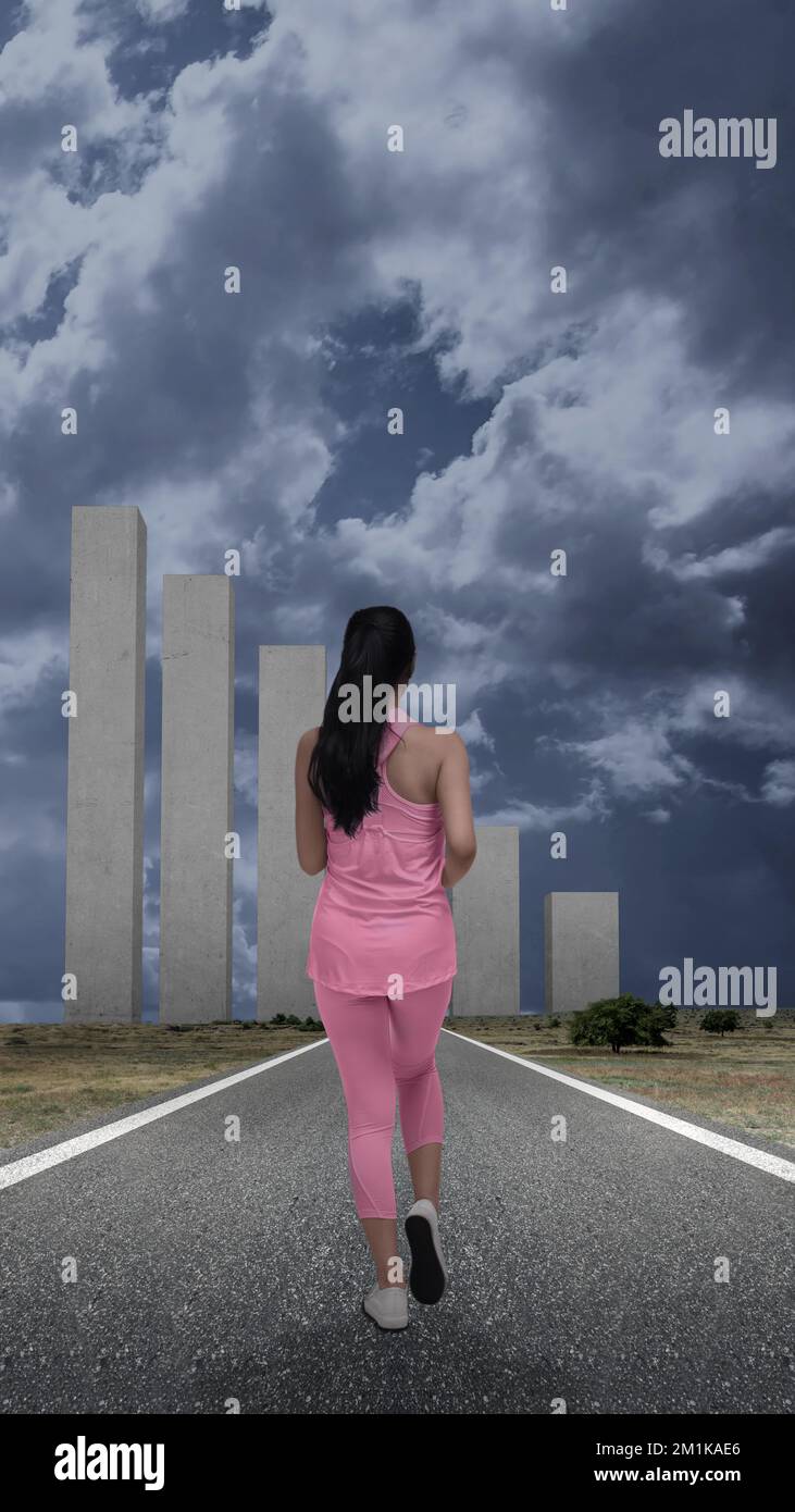 Vista posteriore della donna asiatica che corre sulla strada Foto Stock