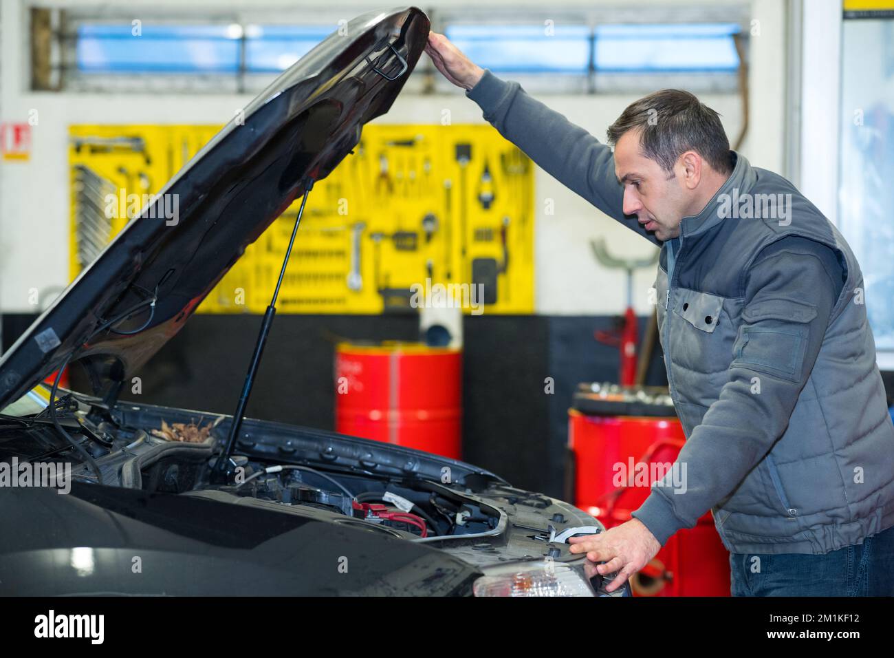 meccanico uomo che ripara un'automobile in un garage Foto Stock