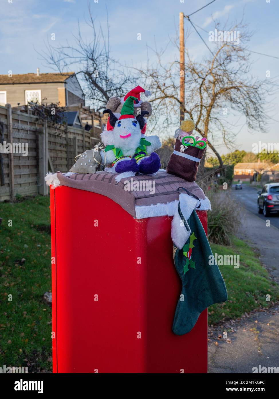 Creature a maglia o toppers su una scatola rossa di posta, Piddington Village, Northamptonshire, Regno Unito Foto Stock