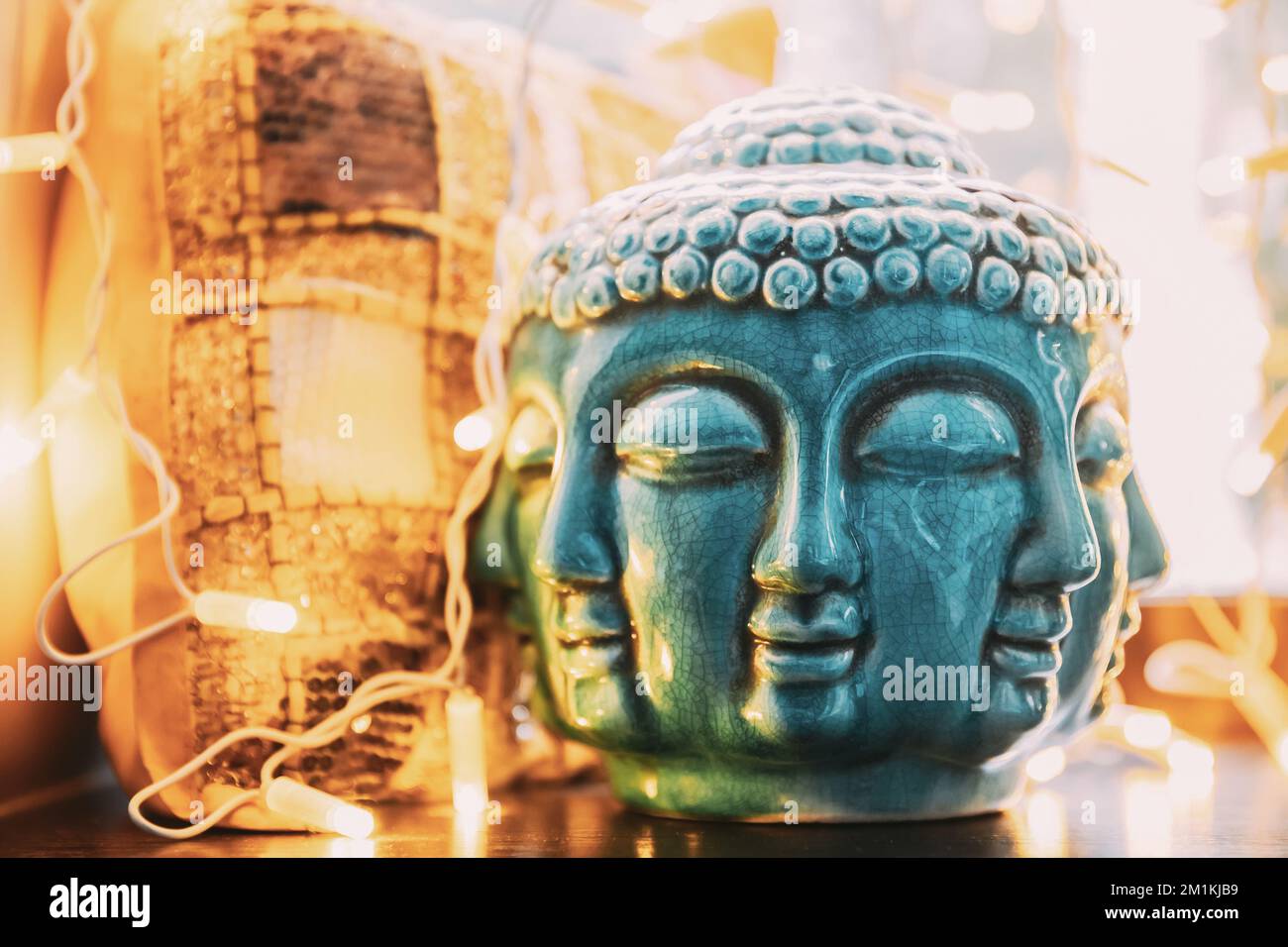 Statua blu della testa di Buddha illuminata da bokeh boke luci. Elemento interno Foto Stock