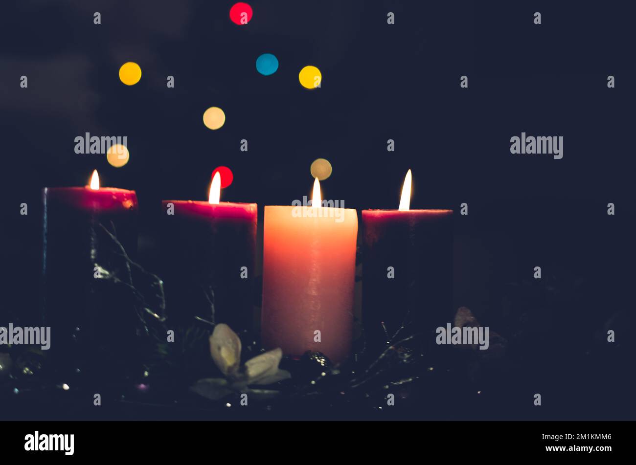 3 candele viola e 1 candele rosa che bruciano sulla corona dell'avvento Foto Stock