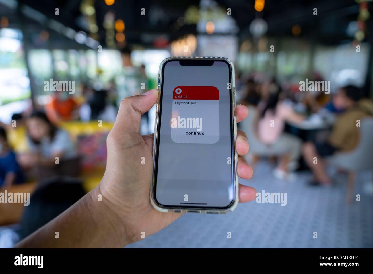 Tenere in mano il telefono cellulare con l'applicazione che effettua il pagamento senza contanti transazione di pagamento. Foto Stock