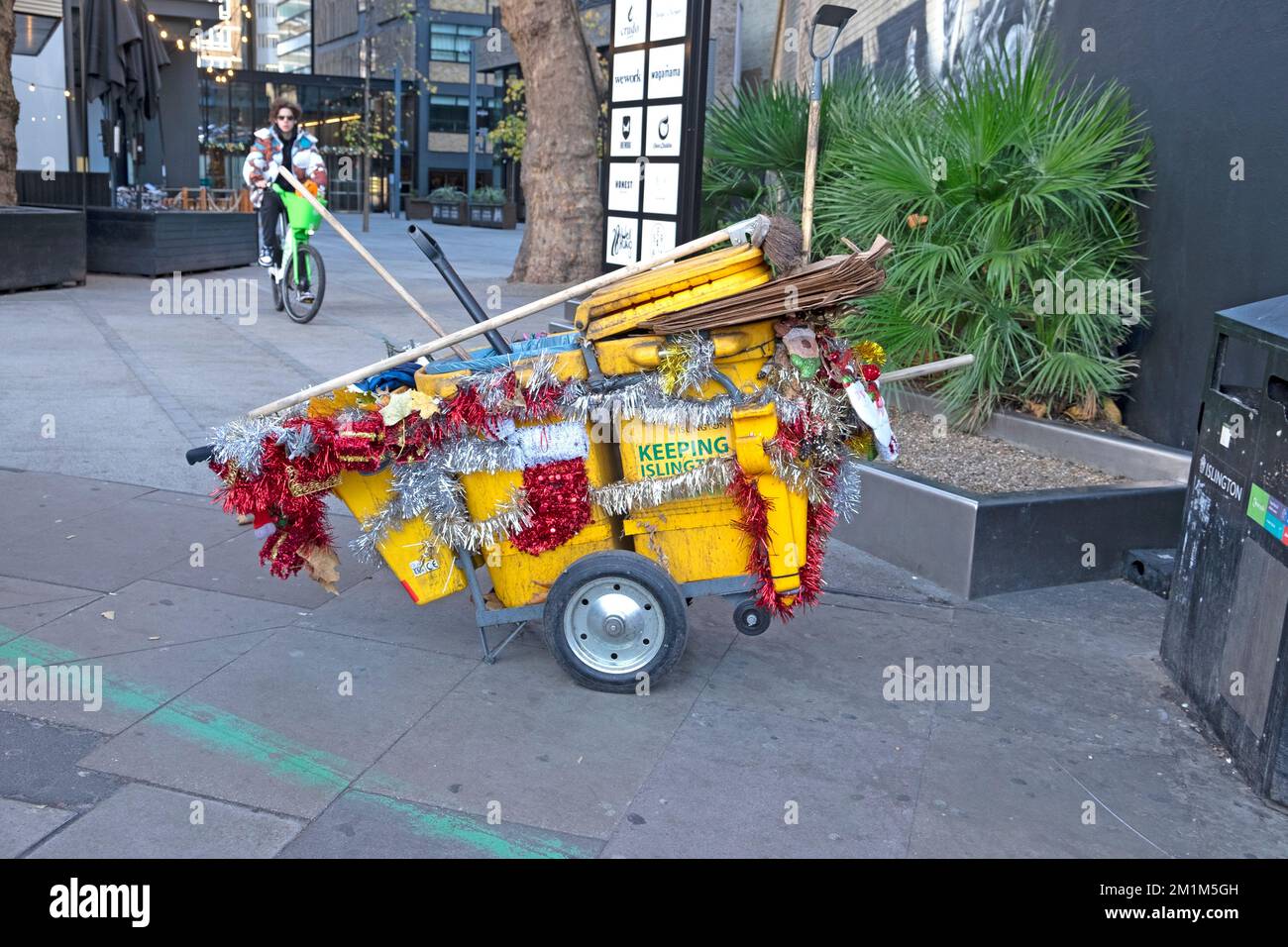 Decorazioni natalizie su un carrello di pulizia della polvere del pulitore della strada da Old Street a Islington Londra Inghilterra Regno Unito Dicembre 2022 Gran Bretagna KATHY DEWITT Foto Stock