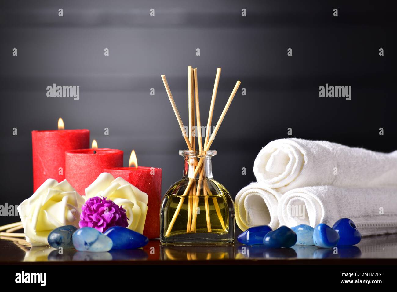 Diffusore aromatico a lamelle con fiori e pietra sul tavolo Foto Stock