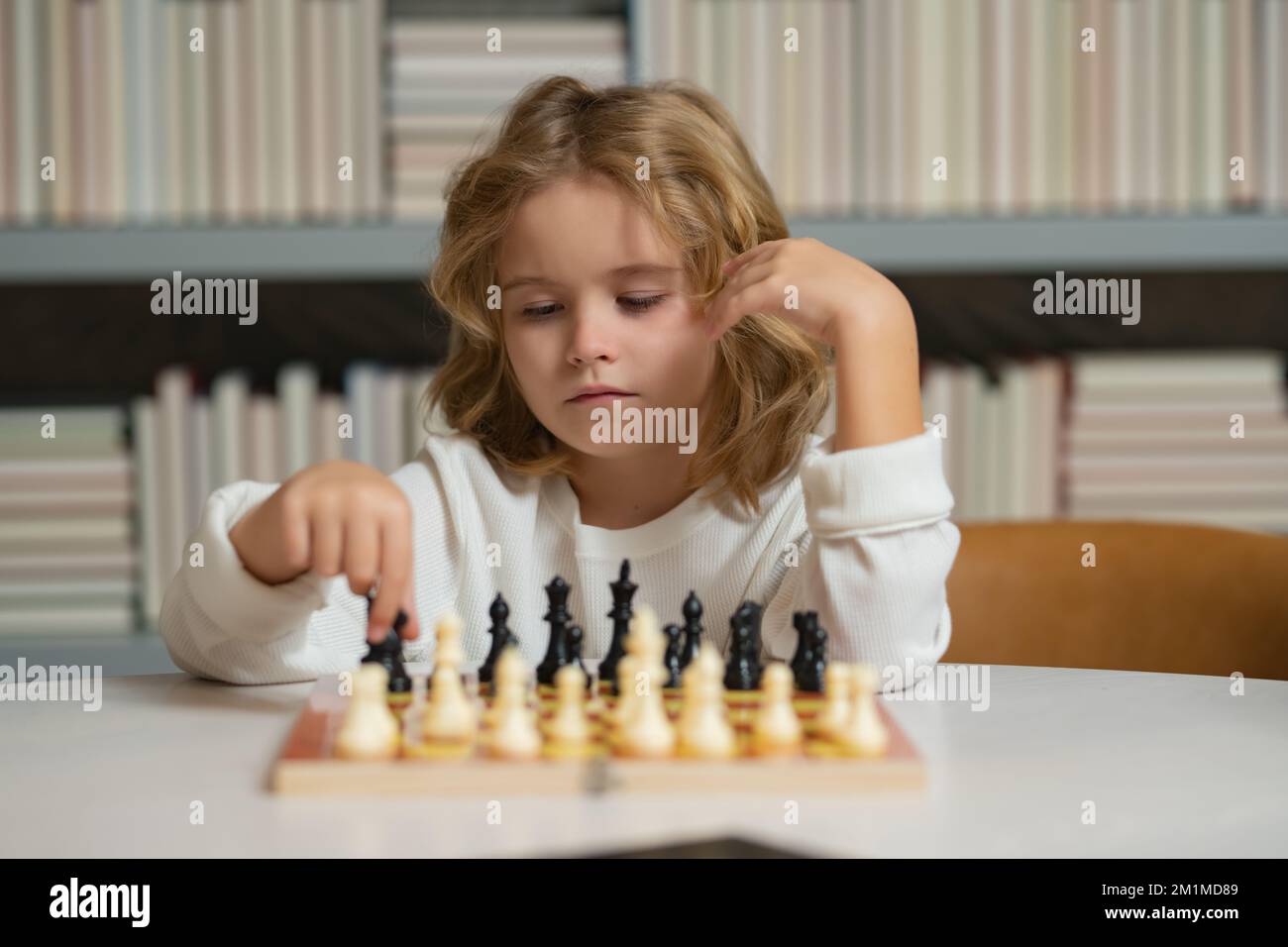 Sviluppo iniziale. Ragazzo che pensa agli scacchi. Il concetto di apprendimento e di crescita dei bambini. Scacchi, successo e vincita. Foto Stock