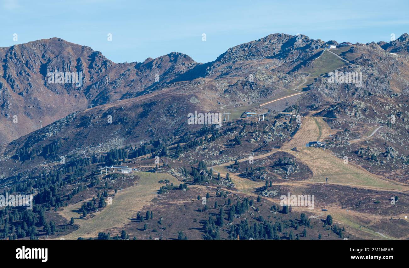 Piste da sci e tow sulle piste delle Alpi austriache in una giornata di sole d'autunno. Neve senza montagne. Clima più caldo. Stagione annullata. Foto Stock