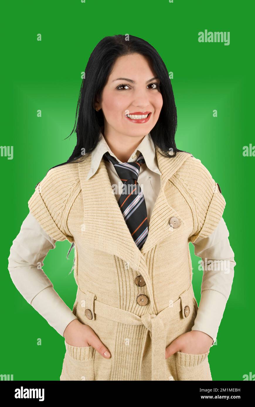 Sorridente bella imprenditrice in un elegante abito con le mani in tasca Foto Stock