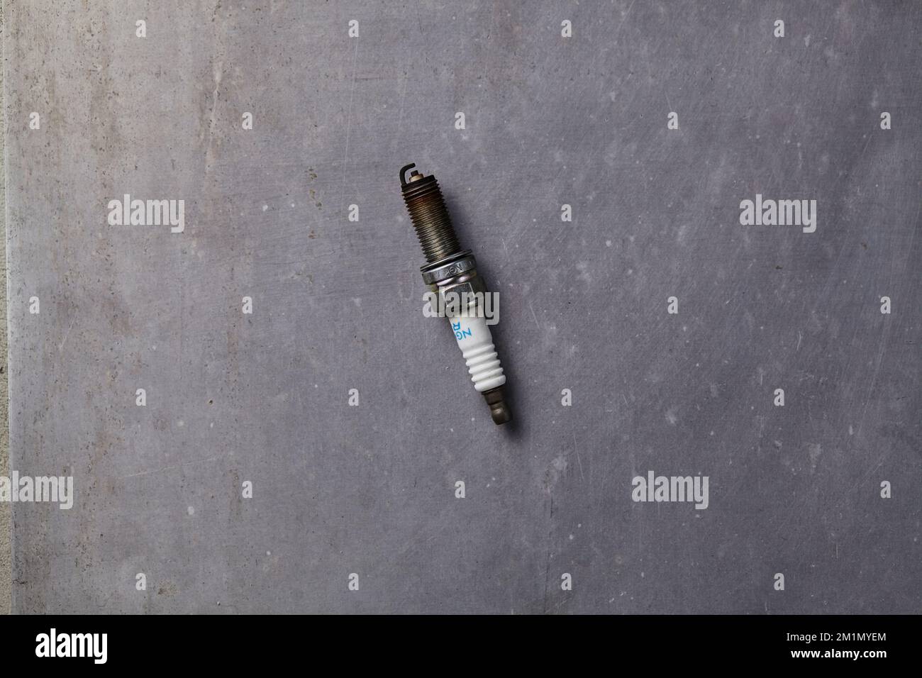 una candela usata sporca su un pavimento grigio Foto Stock