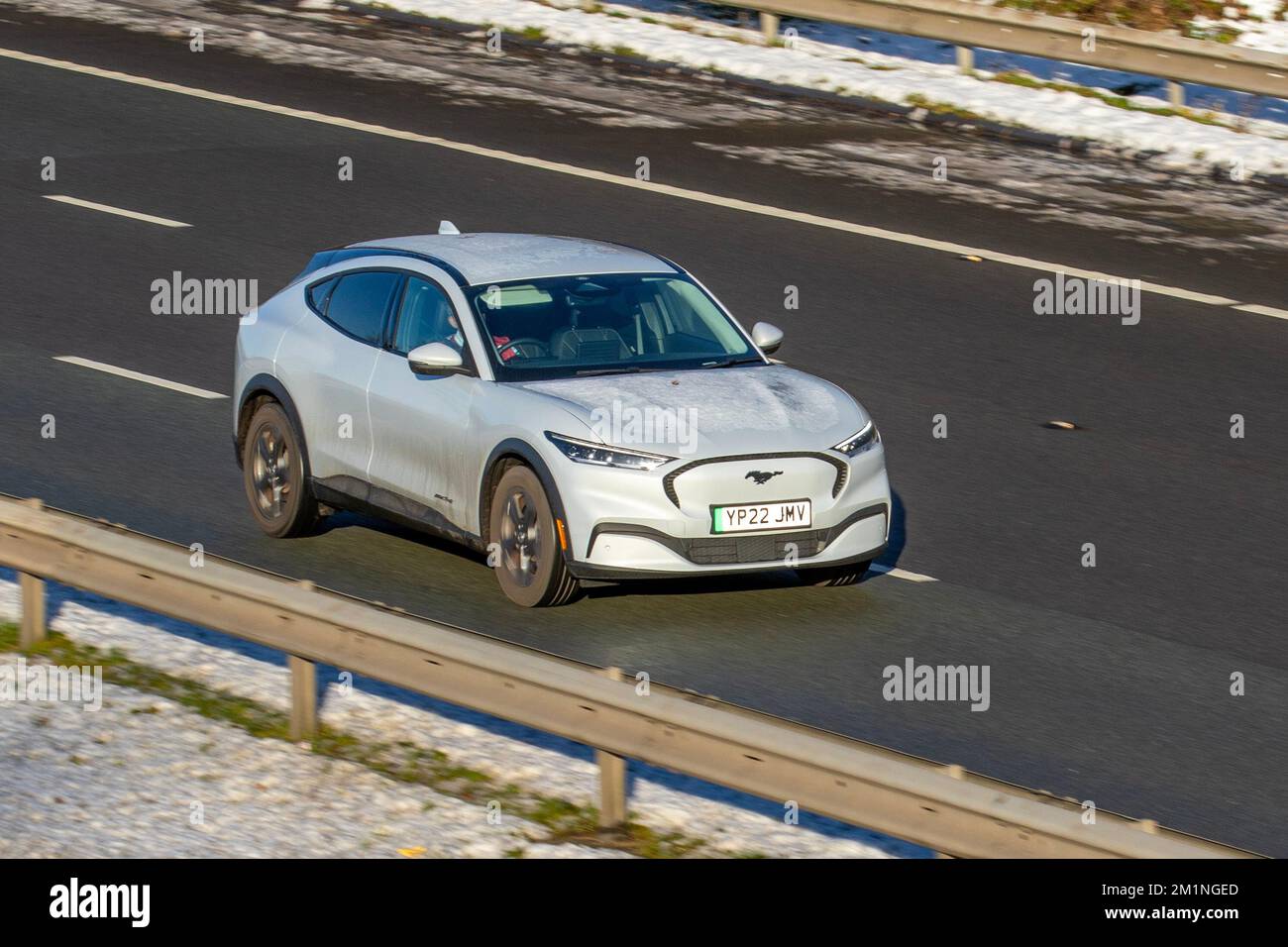 2022 White FORD MUSTANG MACH-e STD GAMMA RWD; auto che viaggiano su una fredda mattina invernale. Inverno basse temperature con gelo a dicembre e condizioni di guida fredde sull'autostrada M61, Regno Unito Foto Stock