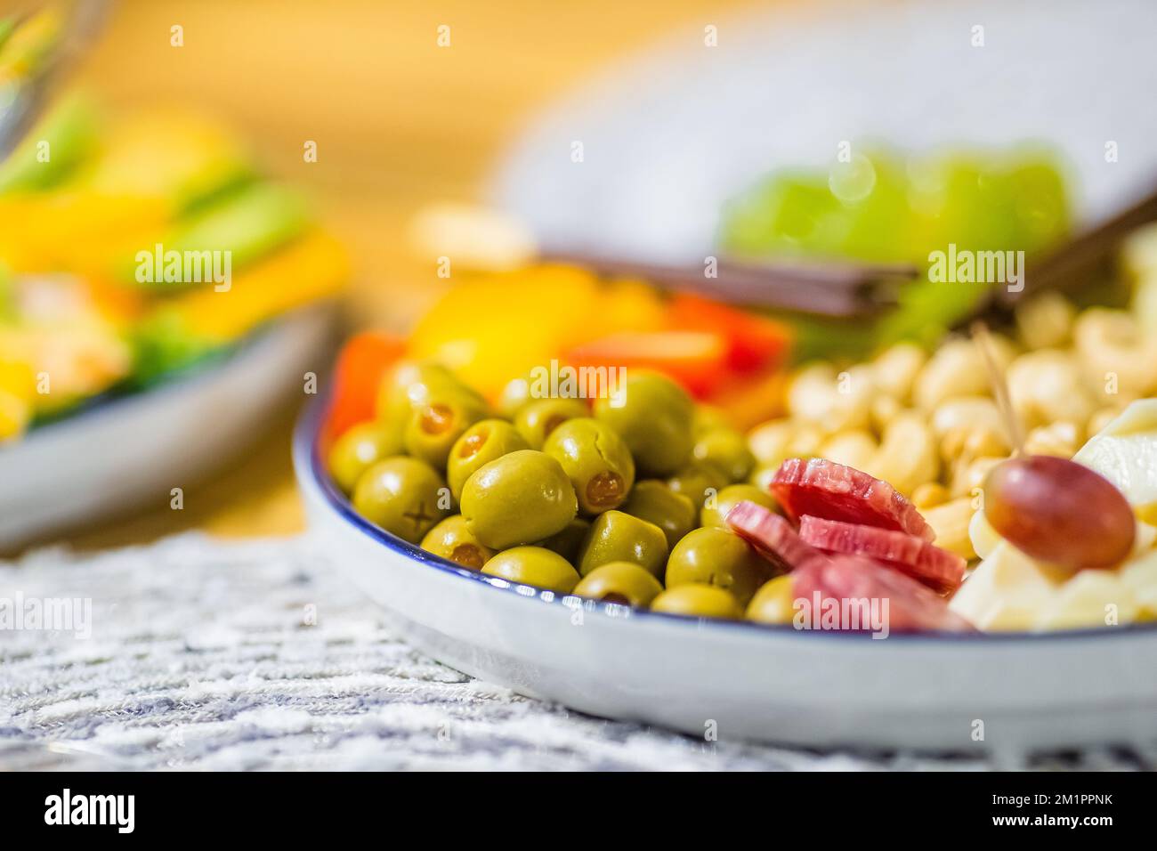 Piatto di antipasti con diversi spuntini, formaggi, olive, frutta e noci Foto Stock
