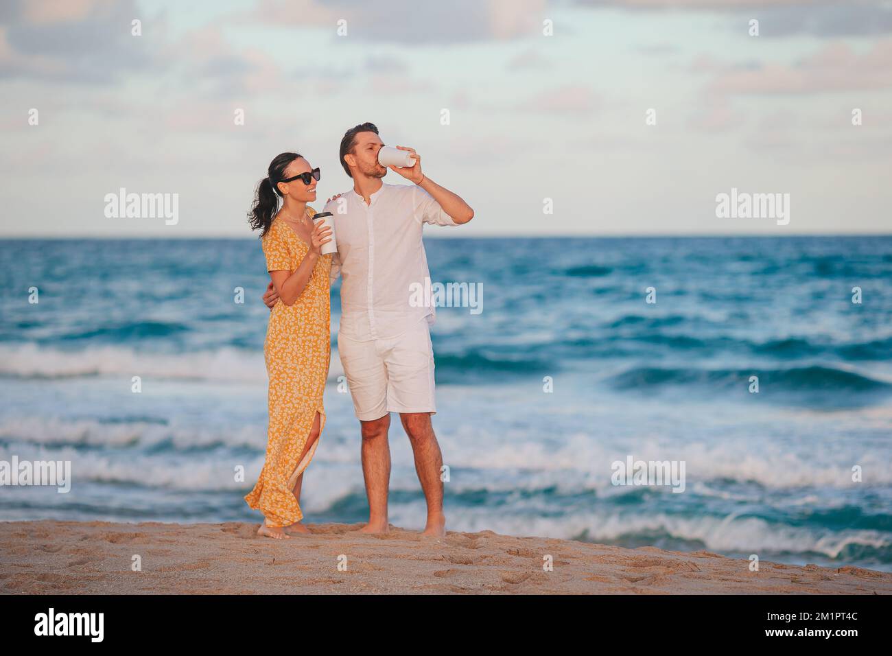 Una giovane coppia in spiaggia si sveglierà e gusterete un caffè Foto Stock