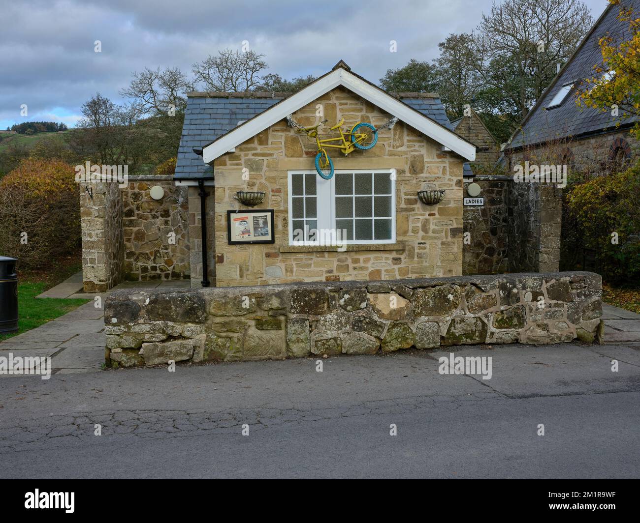 Bicicletta decorativa sulla parte anteriore delle comodità pubbliche in Rosedale Abbey. North Yorkshire Foto Stock