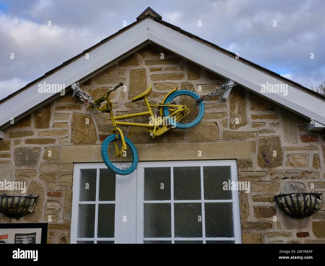 Bicicletta decorativa sulla parte anteriore delle comodità pubbliche in Rosedale Abbey. North Yorkshire Foto Stock