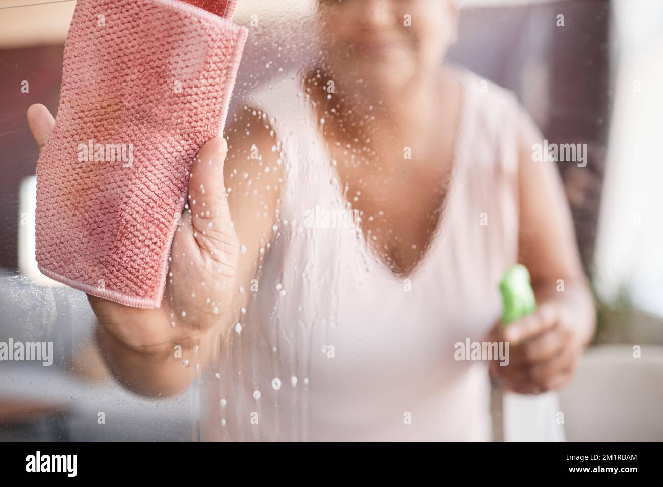Primo piano immagine di sfondo della donna anziana pulizia vetri finestre mettere a fuoco sulla mano tenendo la salvietta, copia spazio Foto Stock