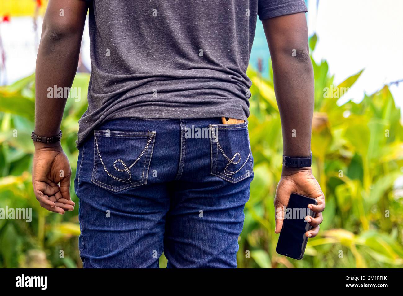 giovane uomo africano che tiene uno smartphone in cantiere Foto Stock