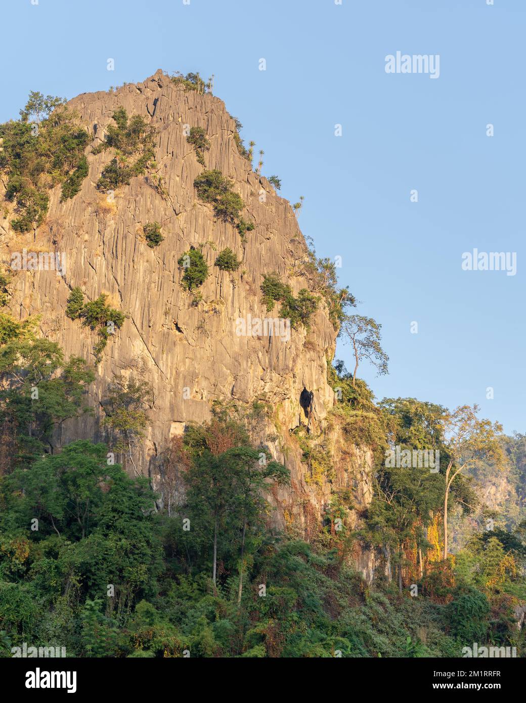 Vista paesaggistica di pietra calcarea o scogliera di montagna carsica che cattura la luce del mattino presto sopra la vegetazione tropicale a Chiang Dao, Chiang mai, Thailandia Foto Stock