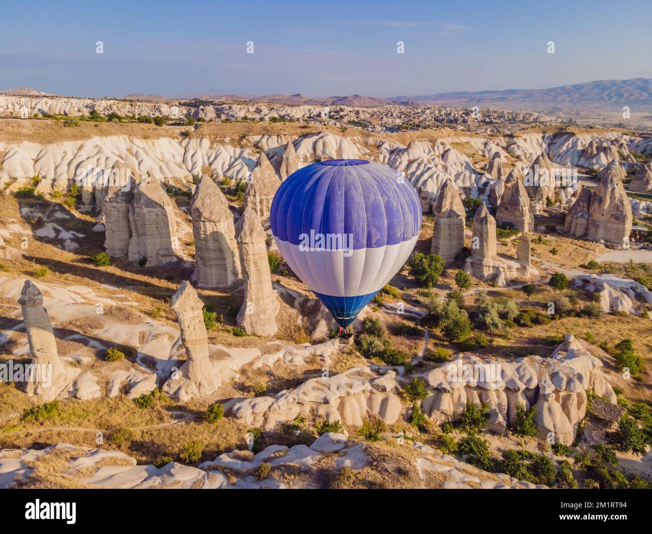 Coloratissime mongolfiere che volano nella valle dei camini delle fate a Nevsehir, Goreme, Cappadocia Turchia. Spettacolare vista panoramica del drone Foto Stock