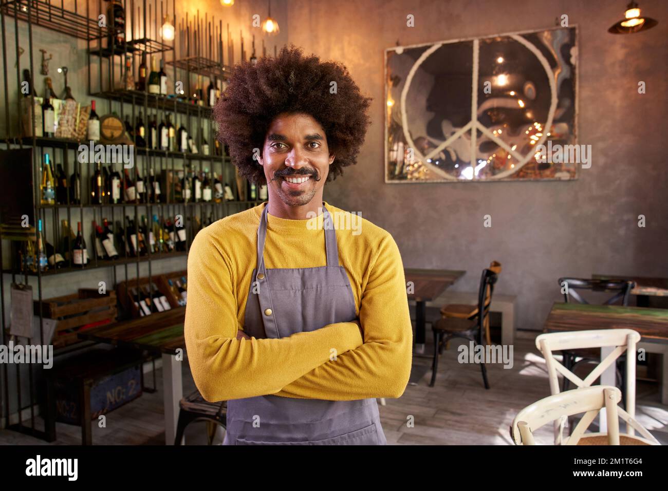 Guardando il ritratto della macchina fotografica di un giovane proprietario di una piccola impresa locale. Afro capelli afro-americani dell'uomo Foto Stock