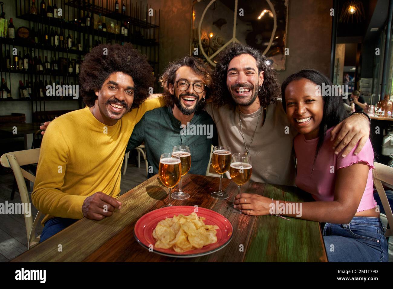 Ritratto di gruppo di amici che guardano la macchina fotografica in un bar ristorante dopo il lavoro al pub happy hour Foto Stock