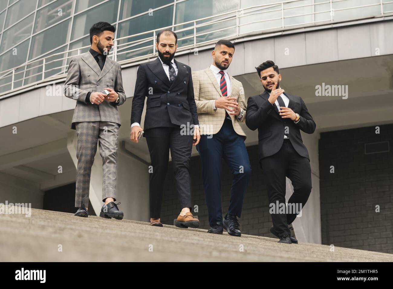 Riunioni all'aperto per uomini d'affari. Una compagnia di uomini d'affari  maschi in abiti discendono giù per le scale della strada. Interruzione di  lavoro. Lavoro di squadra e brainstorming Foto stock - Alamy