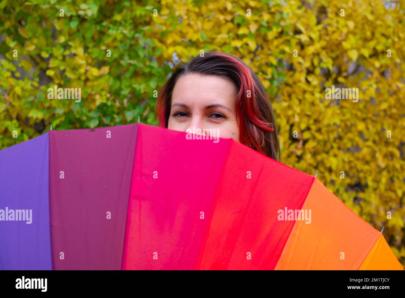 l'arcobaleno enorme ombrello e una ragazza che peeking fuori Foto Stock