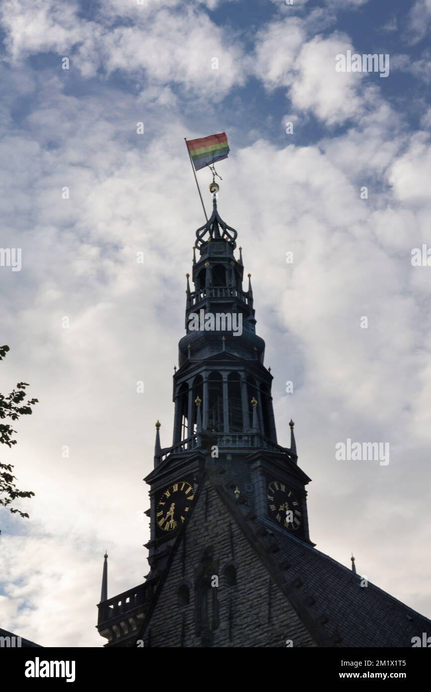 Famoso edificio a torre Oudekerk con bandiera di orgoglio che sventola in cima al tramonto soleggiato Foto Stock