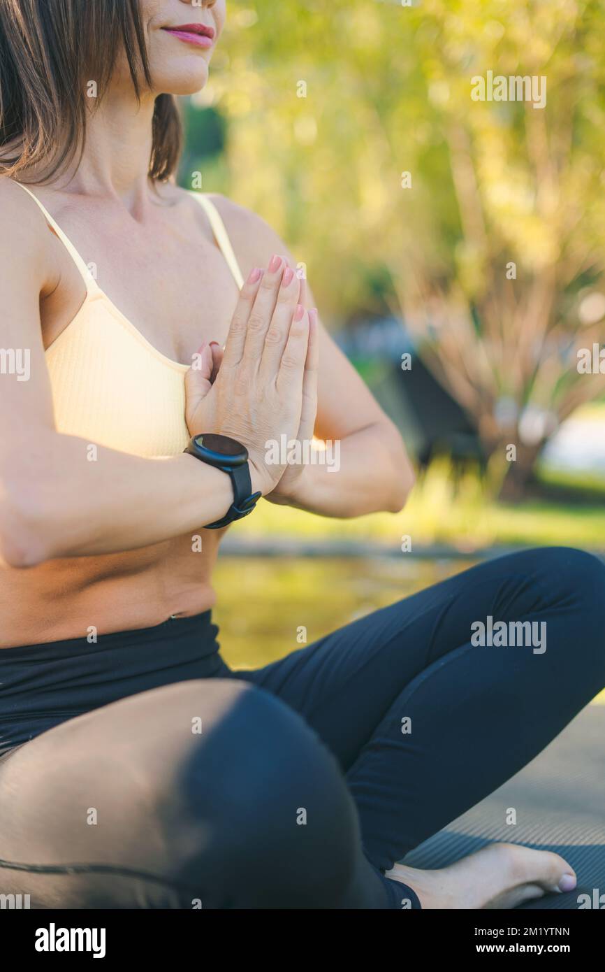 Primo piano delle mani della donna nel gesto di preghiera. Meditazione femminile all'aperto. Posizione di preghiera. Foto Stock