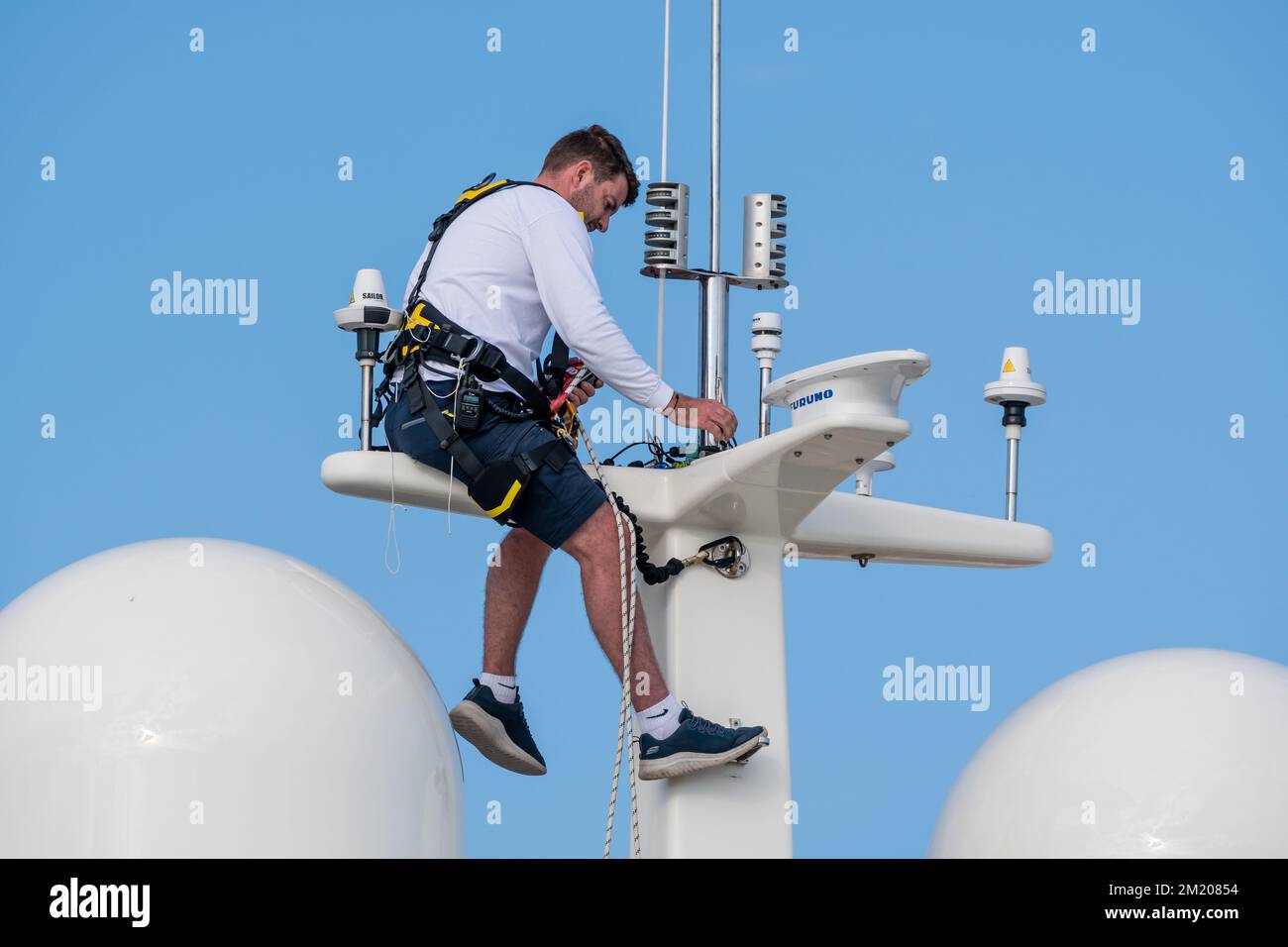 L'uomo, l'imbracatura di sicurezza, la riparazione del GPS e del radar devono essere a bordo di uno yacht privato, Vilanova Grand Marina, Vilanova i la Geltrú, Barcellona, Catalogna, Spa Foto Stock