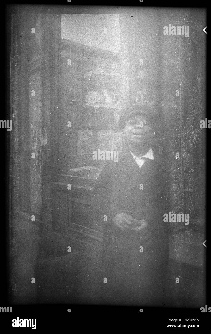 Un ragazzo che indossa un cappello si trova di fronte a un negozio, Boys. Collezione Jack Miller Foto Stock