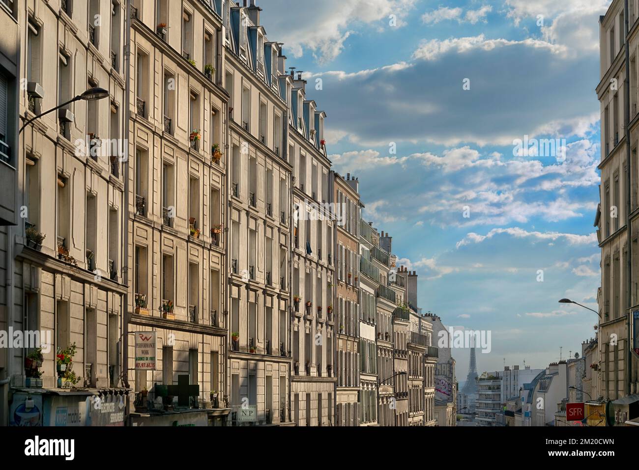 La vista che guarda a sud-est lungo rue de Belleville verso la Torre Eiffel dall'intersezione di rue des Pyrénées. Foto Stock
