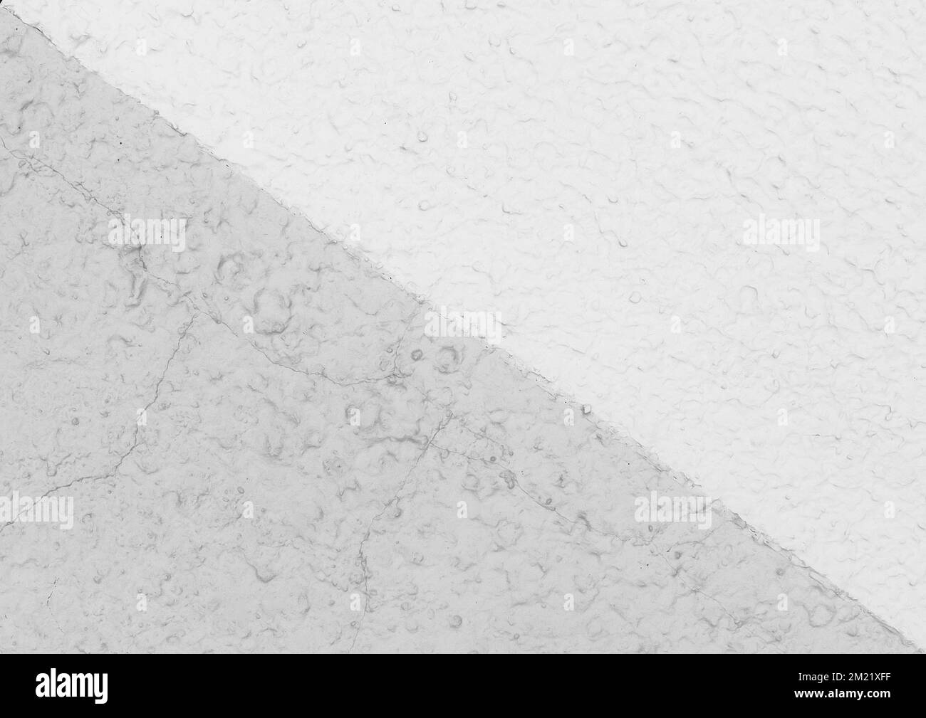 Linea diagonale su una parete in gesso bianco a due colori - sfondo a trama chiara. Foto Stock